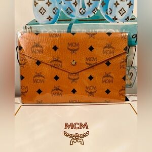 MCM Cognac Color with black MCM pouch/clutch. Comes with box. NEW!!! 9”X6” GWP